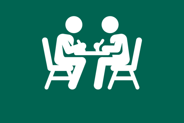 Two people sit opposite each other at a table